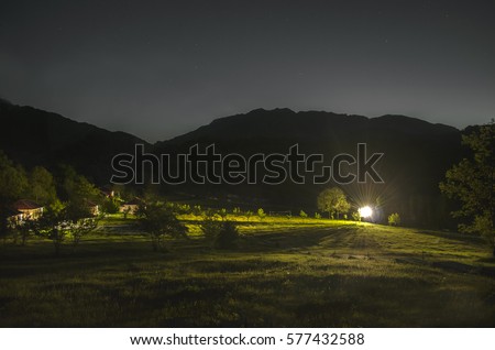mountain panorama night landscape. valley with grass on hillside of mountain range. Green meadow with houses and strong light. Caucasus, Lahic, Azerbaijan