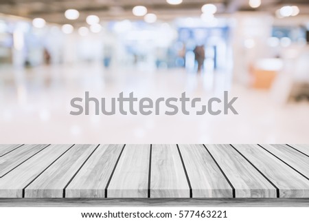 Empty wooden table with blur shopping mall background. For display or montage your products.