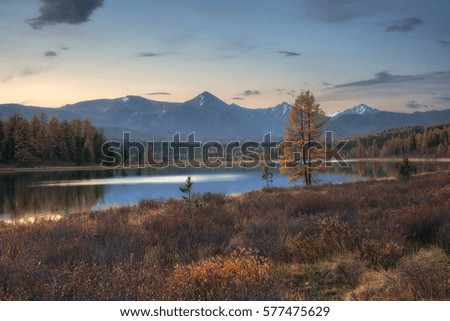 Mirror Surface Lake Autumn Landscape With Mountain Range On Background With Light Pink Sky
