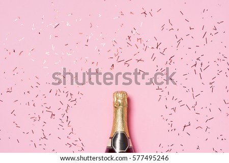 Flat lay of Celebration. Champagne bottle with colorful party streamers on pink background. Royalty-Free Stock Photo #577495246