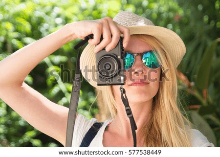 face of young blonde woman photographer taking photo with camera