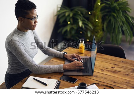 Skilled female business coach working on freelance consulting entrepreneurs and startuppers online typing messages and chatting with clients while sitting in cabinet using laptop computer and wifi