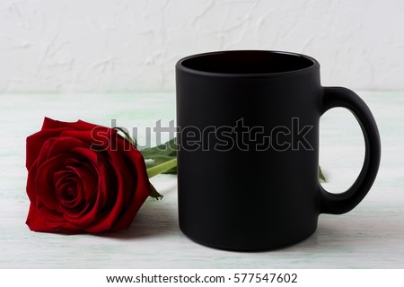 Black coffee mug mockup with red rose. Empty mug mock up for brand promotion.