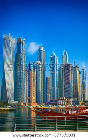 Traditional Arabic wooden ship (Abra) for tourists against the background of skyscrapers, Marina Walk Royalty-Free Stock Photo #577575031