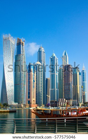 Traditional Arabic wooden ship (Abra) for tourists against the background of skyscrapers, Marina Walk Royalty-Free Stock Photo #577575046