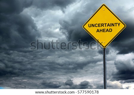 road warning sign with text uncertain ahead in front of storm cloud background Royalty-Free Stock Photo #577590178