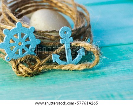 Background with decorative anchors and steering wheels on blue painted wooden planks. Place for text. Top view with copy space