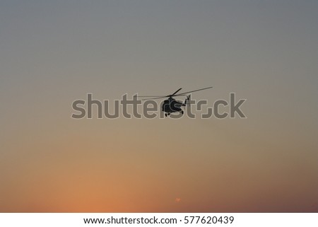 Big Helicopter flying at sunset 
