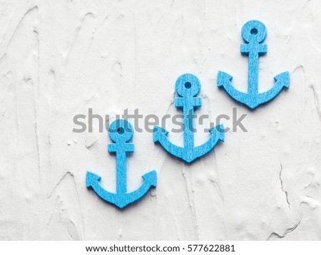 Background with decorative anchors and steering wheels on white painted wooden planks. Place for text. Top view with copy space