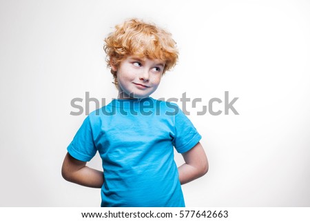 boy hides his hands behind his back, the child is preparing a surprise or a gift, secret, blond boy in blue shirt on a white background
