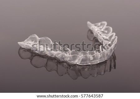 Night guard teeth bruxism protection isolated on the dark background  Royalty-Free Stock Photo #577643587