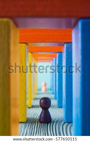 Abstract man into the colorful wooden corridor. Concept of success. Abstract man in a multicolored wooden tunnel. Two persons walk to the light in the end of the tunnel.