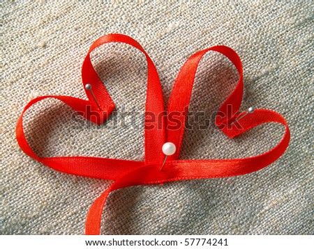 red ribbons heart on the rough canvas
