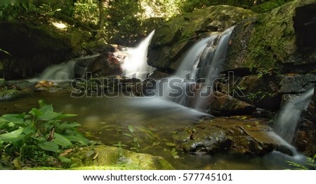 Waterfall landscape photo in rain forest jungle. Motion blur water captured with slow shutter.