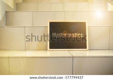 Black board on stairs with message "mathematics". Lenses flare effect applied