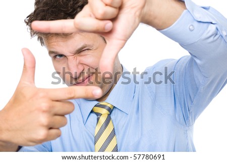 young photographer trying to compose a frame for photograph using his hands and fingers, studio shoot isolated on white background