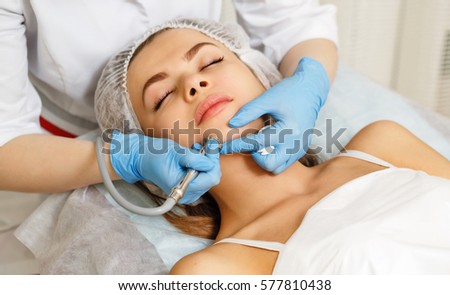Dermabrasion girl chin. Hardware cosmetology. Spa. Facial Rejuvenation. Mechanical peeling skin. Royalty-Free Stock Photo #577810438