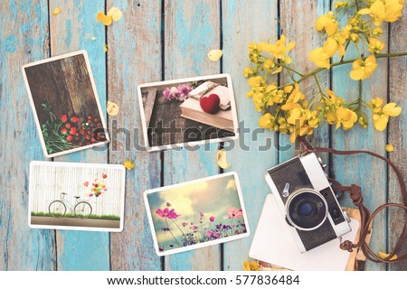 Retro camera and instant paper photo album of valentine day on wood table - photo of remembrance and nostalgia in spring. vintage style