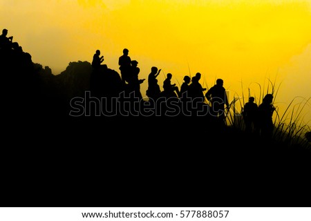 Silhouette of anonymous people at the top of the hills during sunset