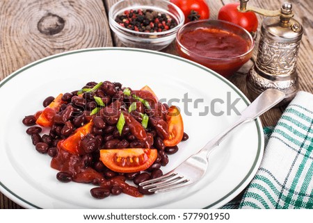 Red beans, tomatoes, ketchup, onion and spices on the white plate. Studio Photo