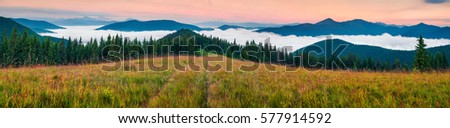 Foggy morning panorama of Carpathian mountains. Colorful summer morning on the mountain valley, Tatariv village location, Ukraine, Europe. Beauty of nature concept background.

