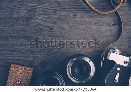 Old camera and lenses on dark wooden background