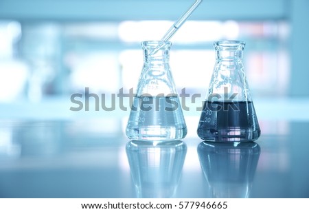 two flask with pipette drop in water at science laboratory background Royalty-Free Stock Photo #577946665