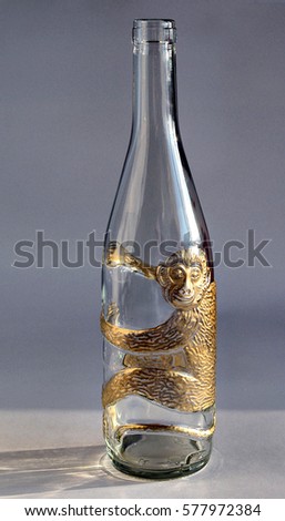 Empty glass bottle with a picture of a monkey