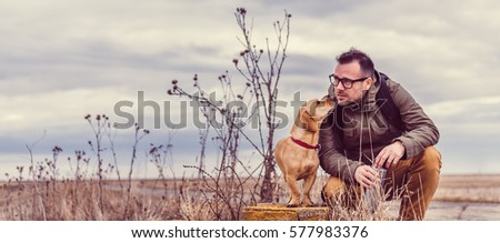Hiker and dog resting on old brick wall