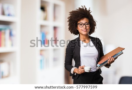 business black woman holding a cup of coffee and files Royalty-Free Stock Photo #577997599