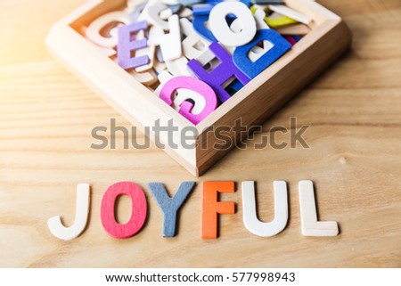 joyful wooden text alphabet on wooden table
