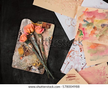 paint brushes and tubes of oil paints on wooden background