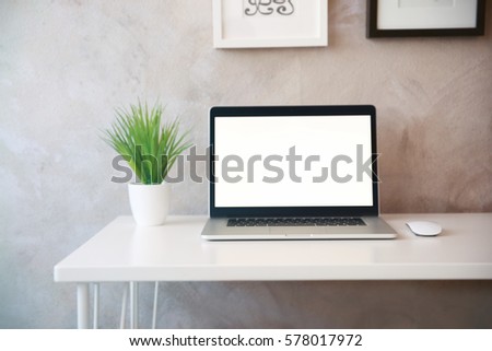 Modern workplace with laptop and plant on table