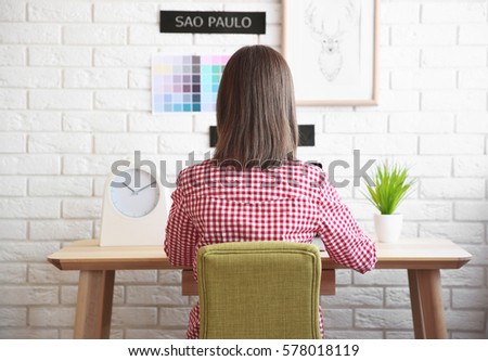 Woman sitting at workplace, back view