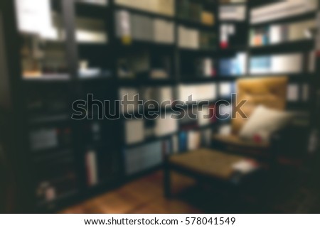 Abstract Blur background of modern dark reading room showroom with arm chair low key lighting decoration wooden table bookshelf for household happy family living visual communication concept design Royalty-Free Stock Photo #578041549