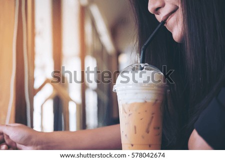 Closeup image of Asian woman drinking Thai tea with feeling good in vintage cafe