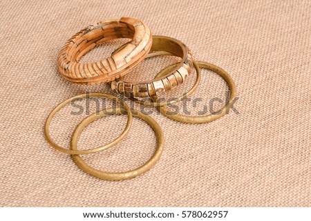 Bracelets of copper and bones on a background of burlap.