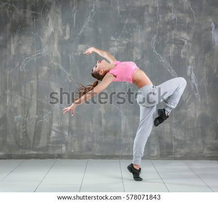 Hip hop dancer dancing on gray background