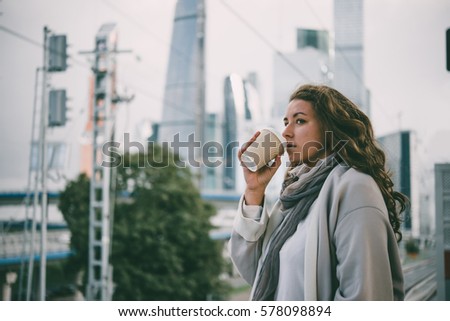 Young beautiful woman enjoys the view of Moscow City international business center. Tourism concept. Toned picture