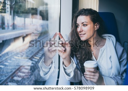 Young beautiful woman looking through the train window. Toned picture