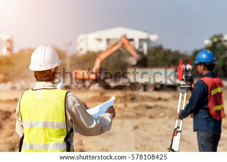 Civil Engineers At Construction Site and A land surveyor using an altometer