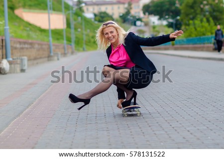 Senior business woman having fun on a skateboard outdoors. The concept of moving forward.