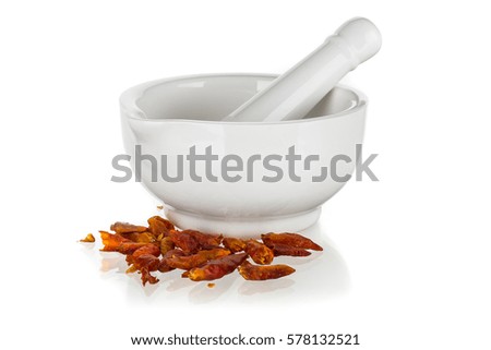 White ceramic mortar with dried chili peppers isolated on white