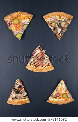 different pizza pieces arranged on a black table