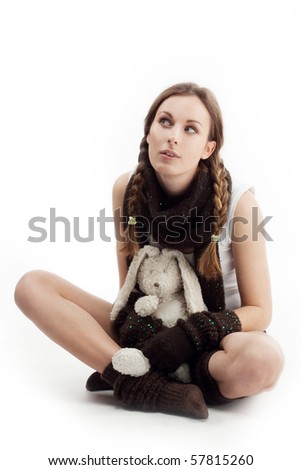The  girl with a plush hare, beautiful girl with plaits embraces a toy