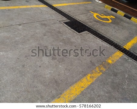 parking lot for disable persons marked yellow painted sign on the floor