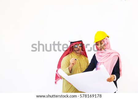 Arabian man with muslim woman are discussing project on white background. Woman engineer is holding blue print.