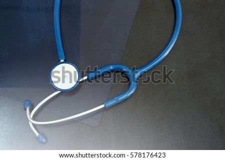 Closed up of Stethoscope on x-ray film on desk working space of doctor,with copy space ,top view,Health care concept