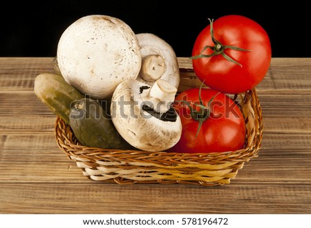 tomatoes, cucumbers and mushrooms on a black background closeup