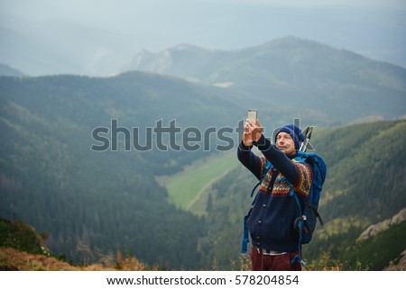 Young hiker taking a selfie from a mountain peak